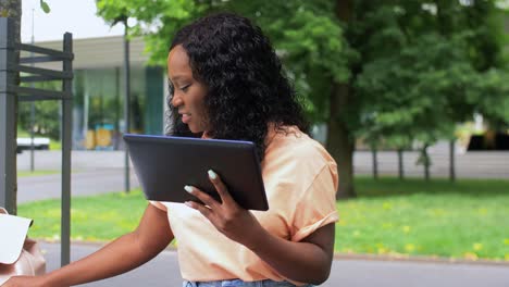 Feliz-Estudiante-Africana-Con-Tablet-Pc-En-La-Ciudad.-Tecnología,-Educación-Y-Concepto-De-Personas-Feliz-Estudiante-Afroamericana-Sonriente-Con-Tablet-Pc-Tomando-Notas-En-La-Ciudad